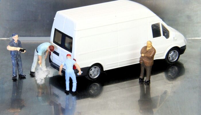 miniature figures of four people and a car emitting exhaust gas